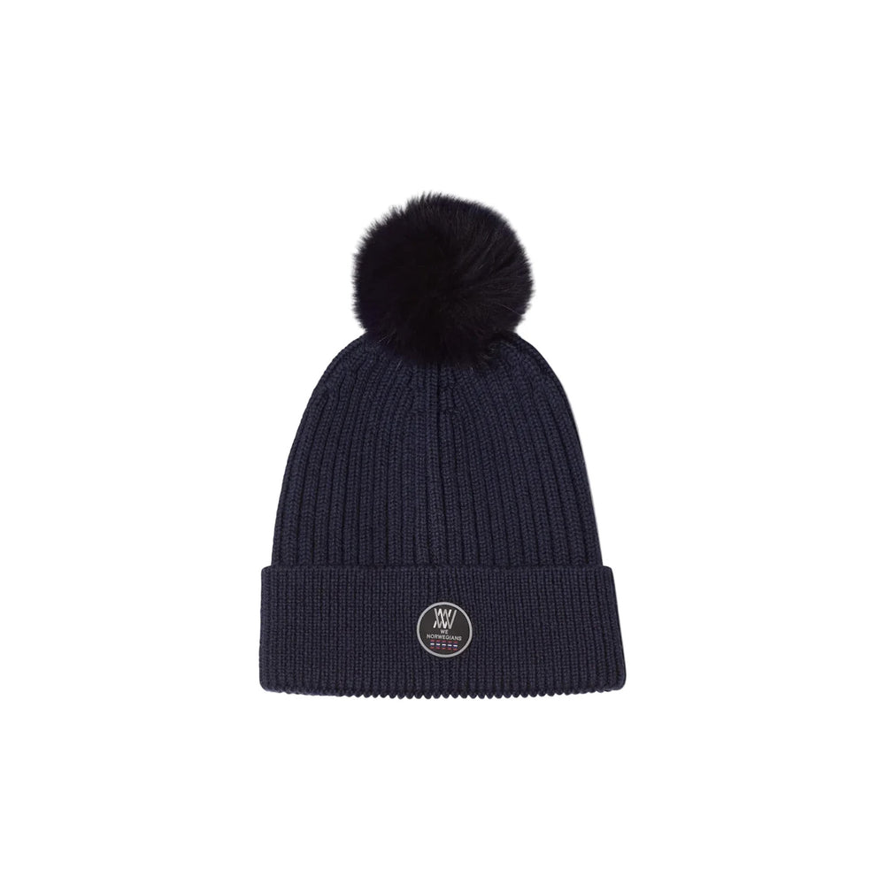 Front view of Hemsedal Hat with ribbed merino knit, folded cuff, silicone logo badge, and pom pom on white background