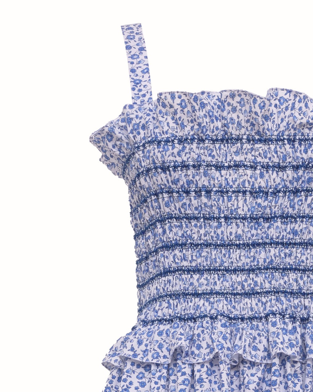 Close-up of Ombretta dress bodice showcasing blue Marina Grande floral smocking, ruffled neckline and thin shoulder strap on white background