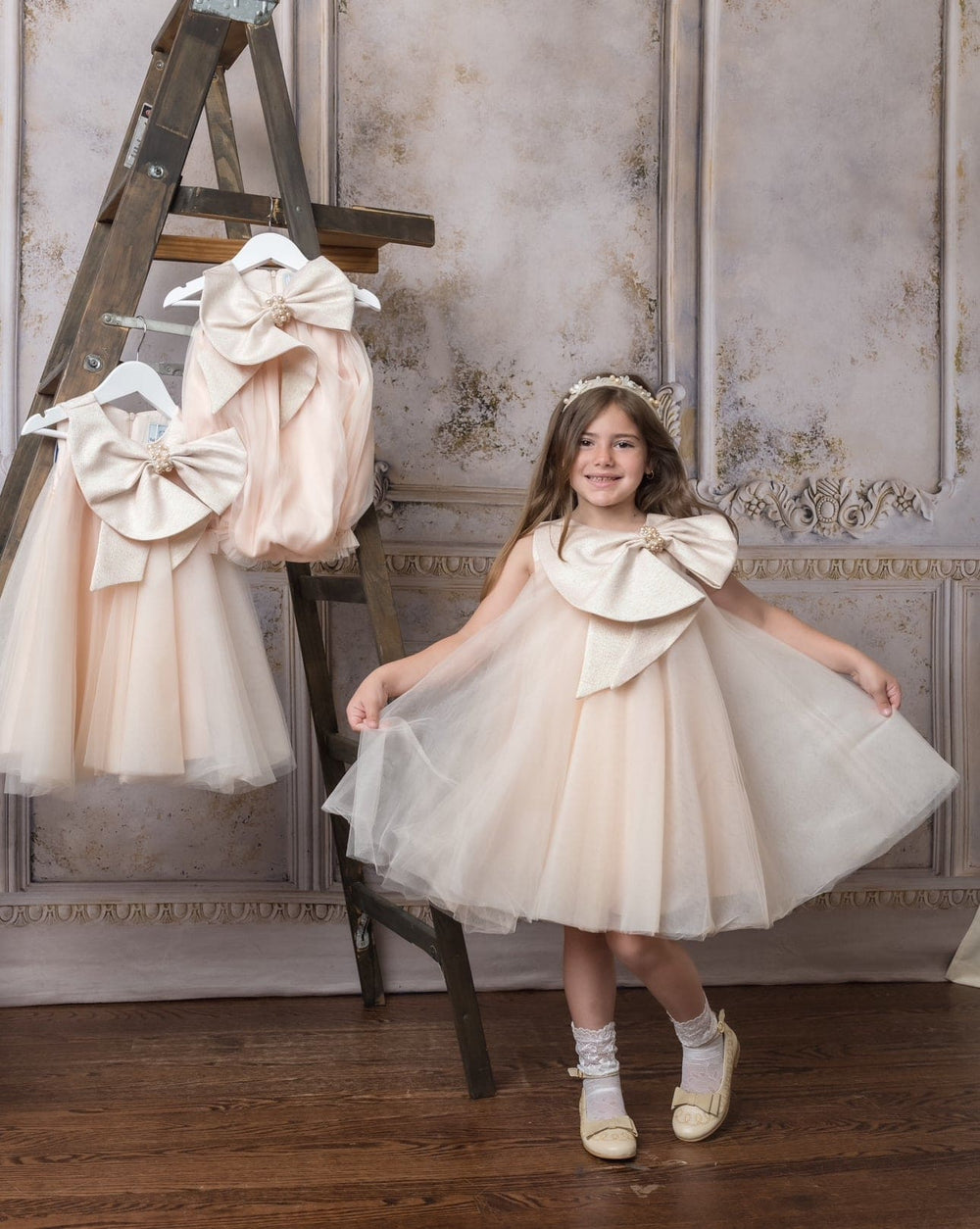 Front of Jackie peach tulle dress on girl, layered A-line skirt and oversized jacquard bow with pearl brooch