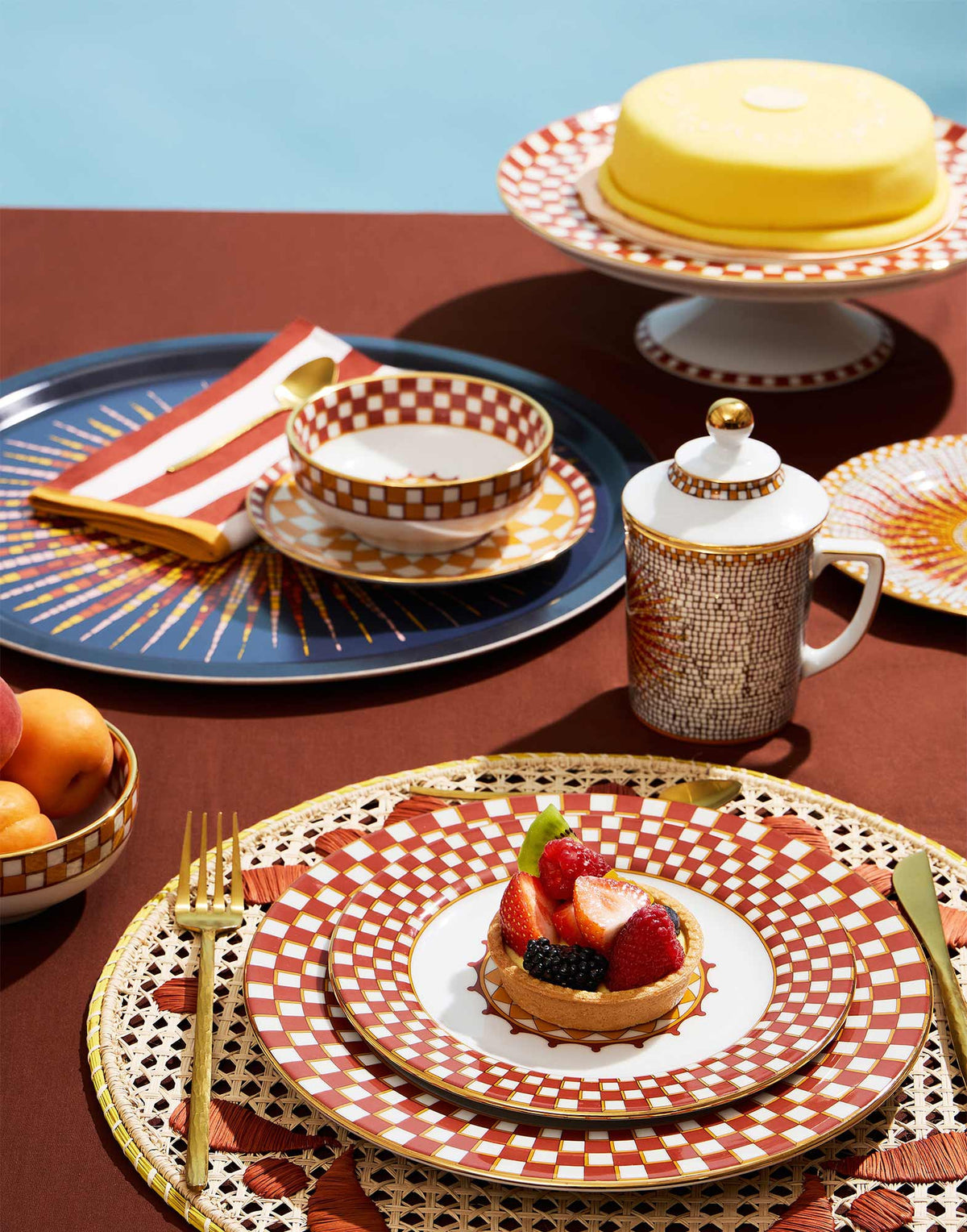 Lidded Mug in Sunrays Multicolor on a colorful table setting with patterned dishes and dessert