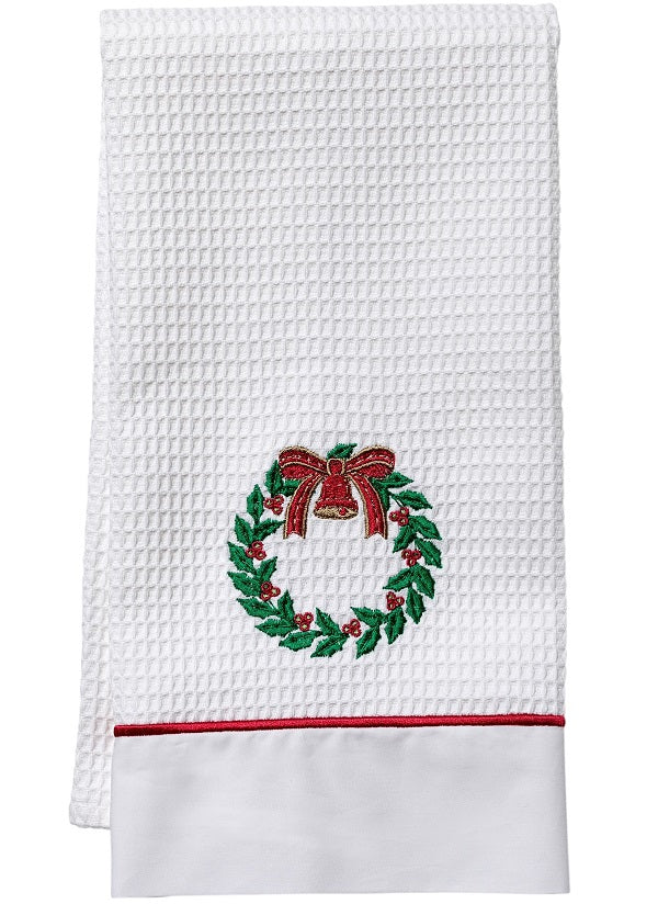Front view of white waffle-weave guest towel showcasing embroidered Christmas wreath with red bow and red-piped percale trim on white background
