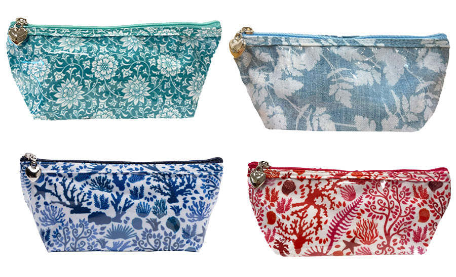 Front view of four X-small cosmetic bags showcasing assorted floral and seashell prints with zipper heart charms on white background