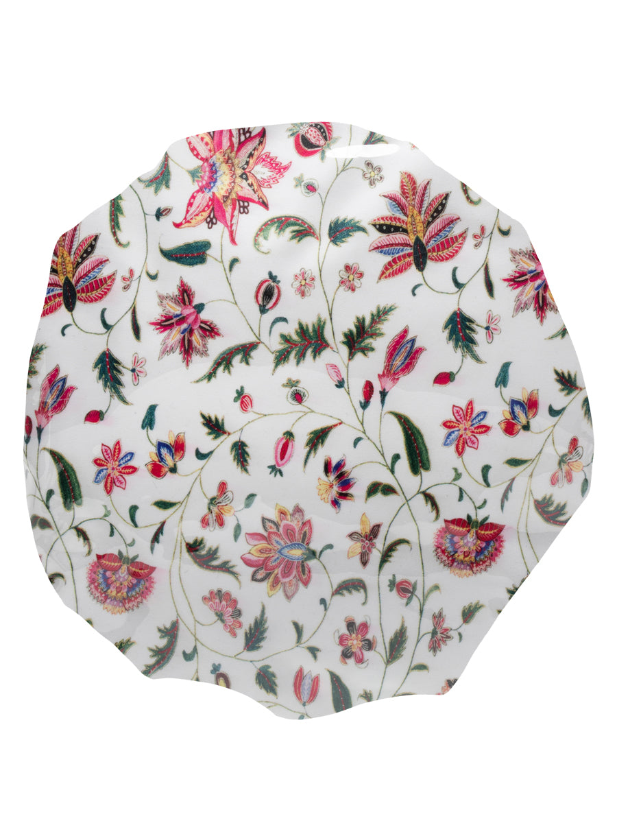 A shower cap with colorful floral print, made of waterproof fabric, worn by a person viewed from the back.