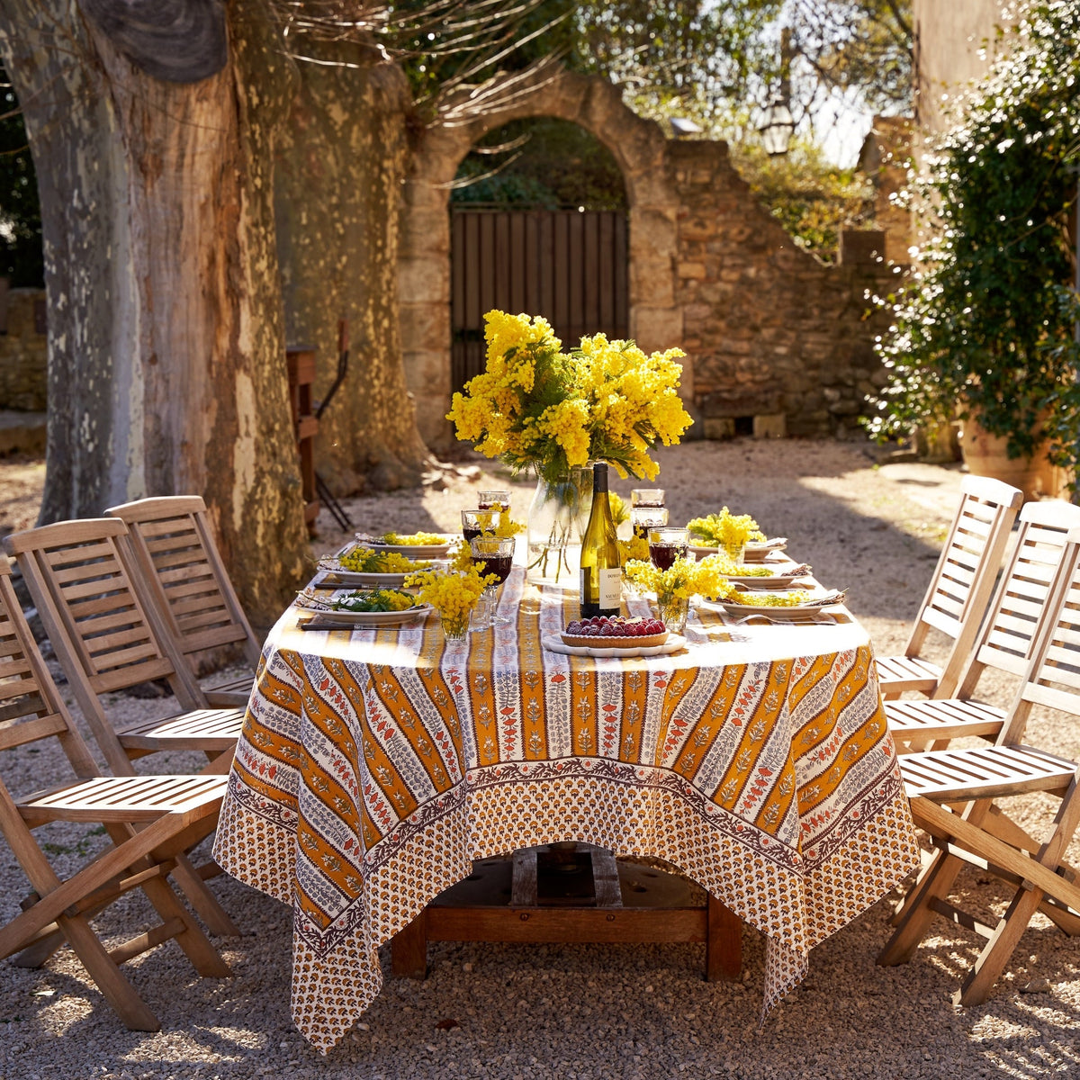 Styled view of French Tablecloth Avignon showcasing its Dijon and blue botanical design on an outdoor dining table