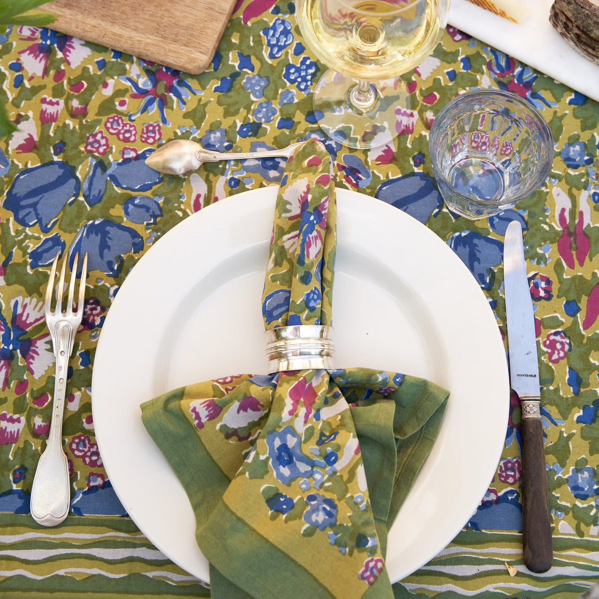 Overhead view of Jardin Napkins Blue and Vert, Set of 6 showcasing a colorful floral pattern on a place setting