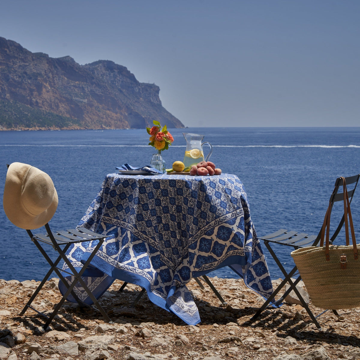 Front view of French Tablecloth Azulejo Blue showcasing blue botanical floral motif with a seaside table setting