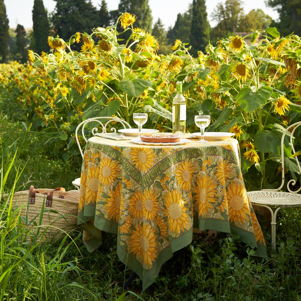 Front view of French Tablecloth Sunflower in Yellow and Green showcasing sunflower pattern on an outdoor table