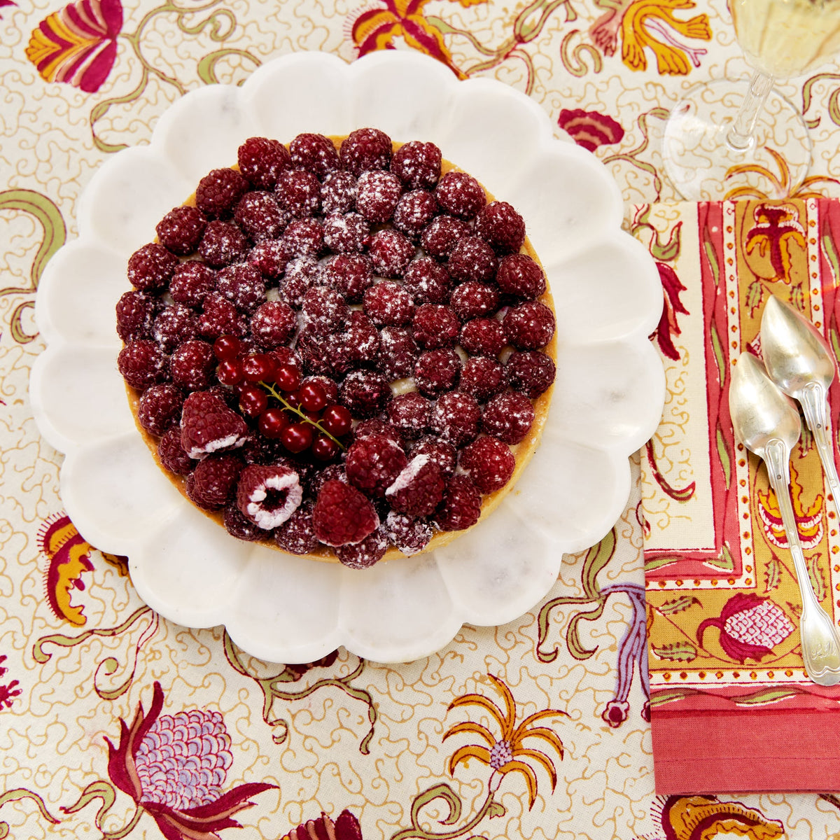 Overhead view of Fleur des Indes Napkins, Set of 6 showcasing colorful floral patterns beside a berry tart