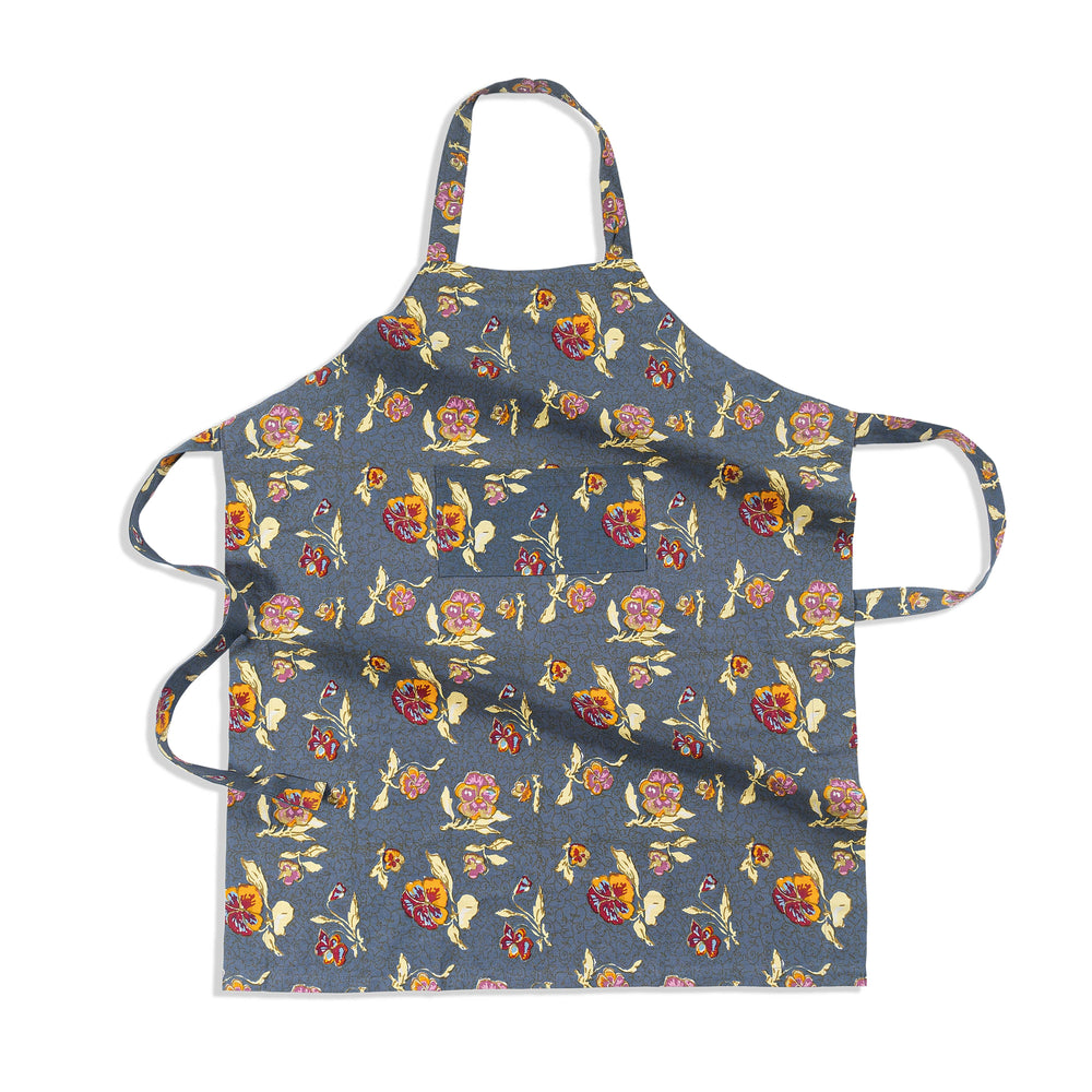 Flat-lay of Pansy apron showcasing red and yellow pansy floral print, center front pocket, neck loop and waist ties on grey background