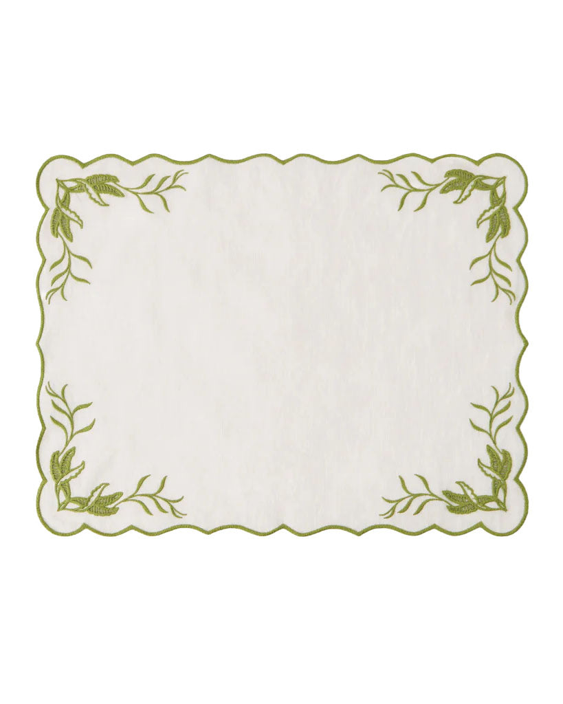 Top view of DESTREE x Cabana embroidered placemat showing scalloped edge and green floral corner embroidery on white background