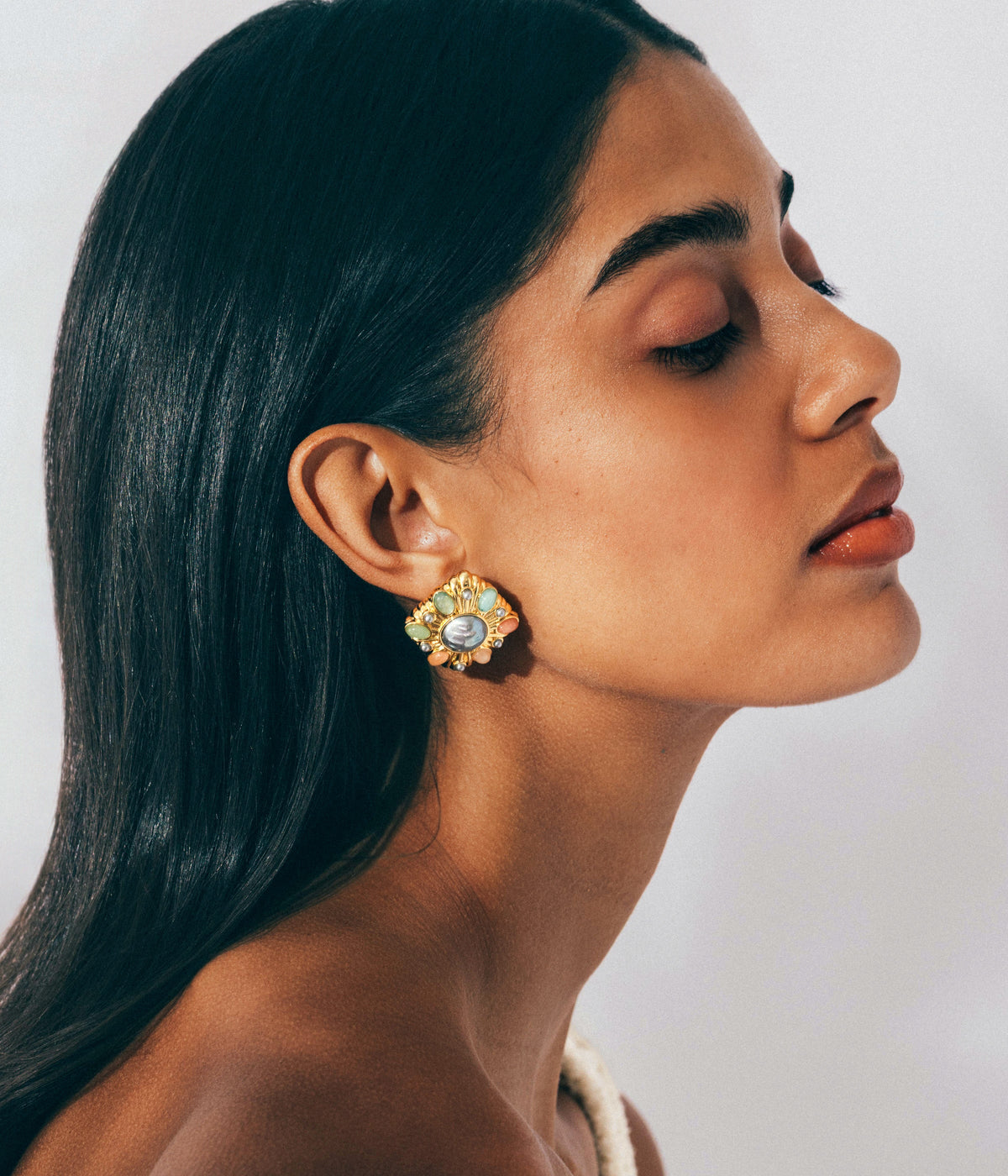Side view of Davis Earrings on model showcasing clustered pastel cabochons in a gold-tone frame against a light background