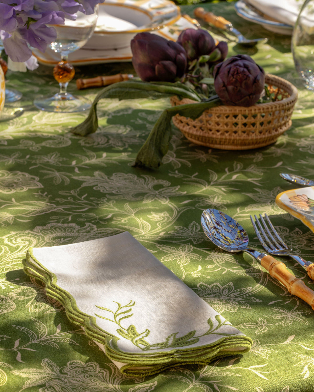 Folded DESTREE x Cabana embroidered napkin with green floral motif and scalloped border on a styled table