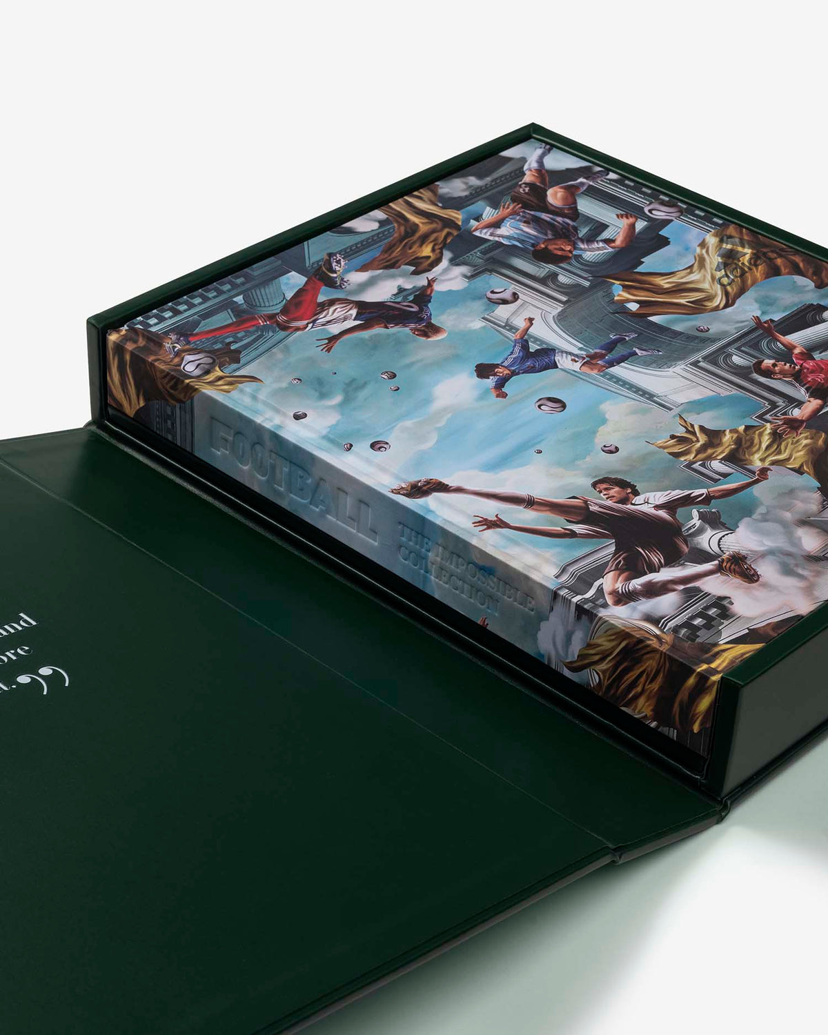 Football: The Impossible Collection by Assouline: angled view of the dark green slipcase open with the inner book being extracted; the book cover shows a dramatic Baroque-style classical painting of multiple figures playing football amid blue sky, clouds, and classical architecture; FOOTBALL THE IMPOSSIBLE COLLECTION on the spine in white; the inside of the dark green lid shows a quote in small white text