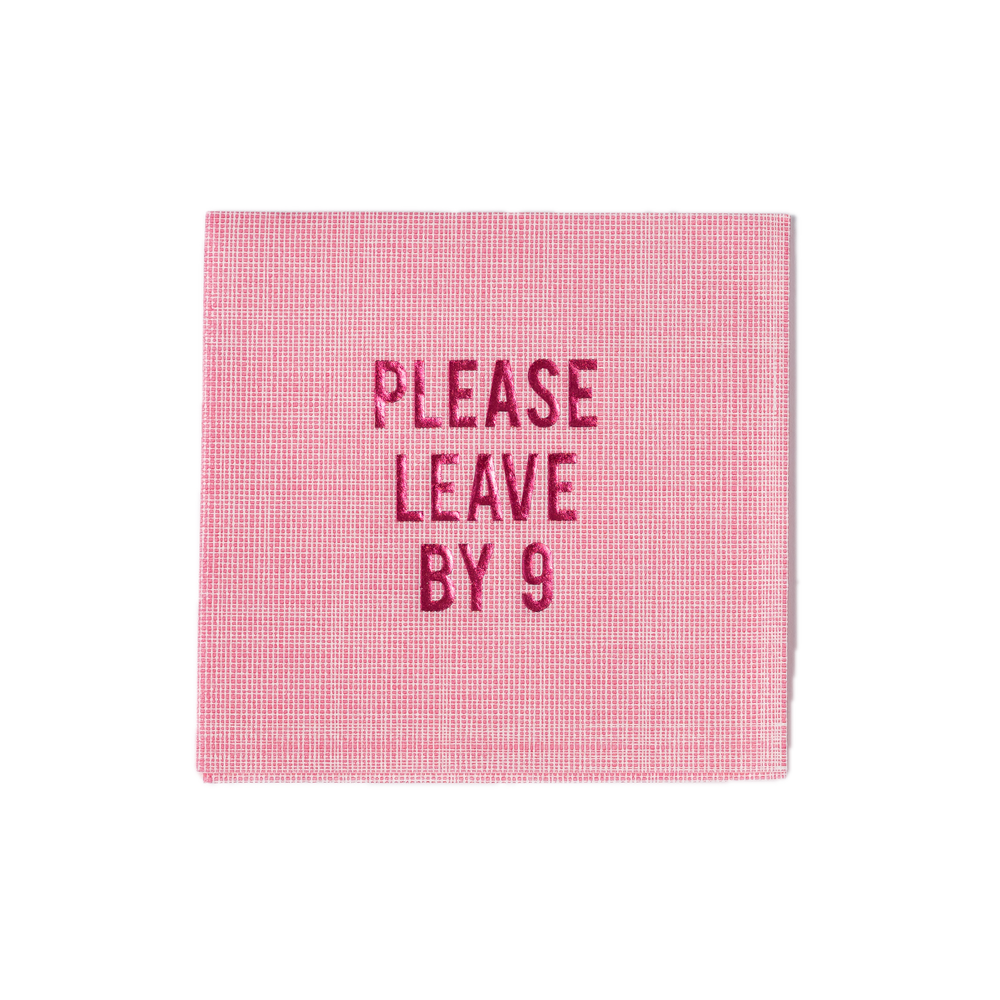 Front view of pink linen disposable cocktail napkin with PLEASE LEAVE BY 9 pink foil text and crosshatch texture on white background