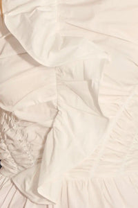 The Doering Top is a fitted V-neck silhouette with ruffles, shirring, and a peplum waist. 