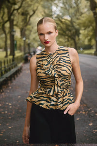 The Doering Top is a fitted V-neck silhouette with ruffles, shirring, and a peplum waist. 