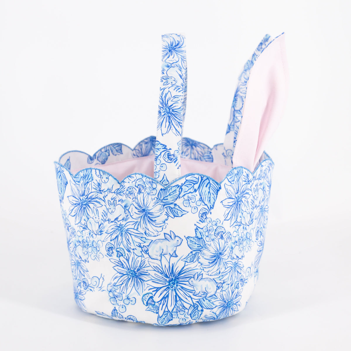 Close-up of Easter Basket in Spring Meadow showcasing propped bunny ear handles and blue floral bunny print with a white background