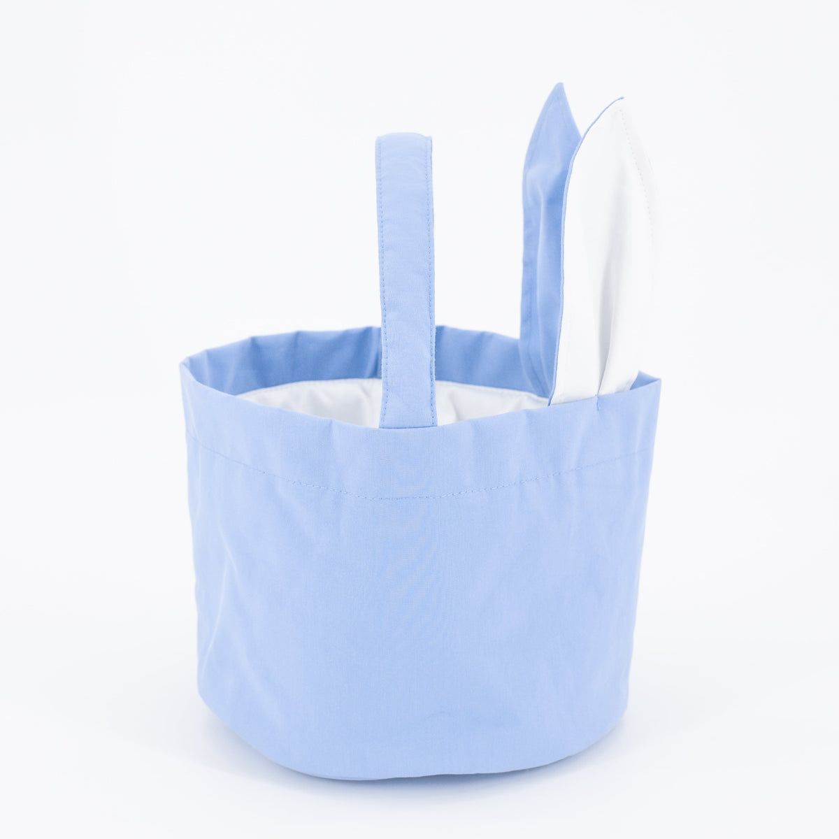 Front view of Easter Basket in Blue showcasing blue fabric, white lining, and stitched handles against a white background