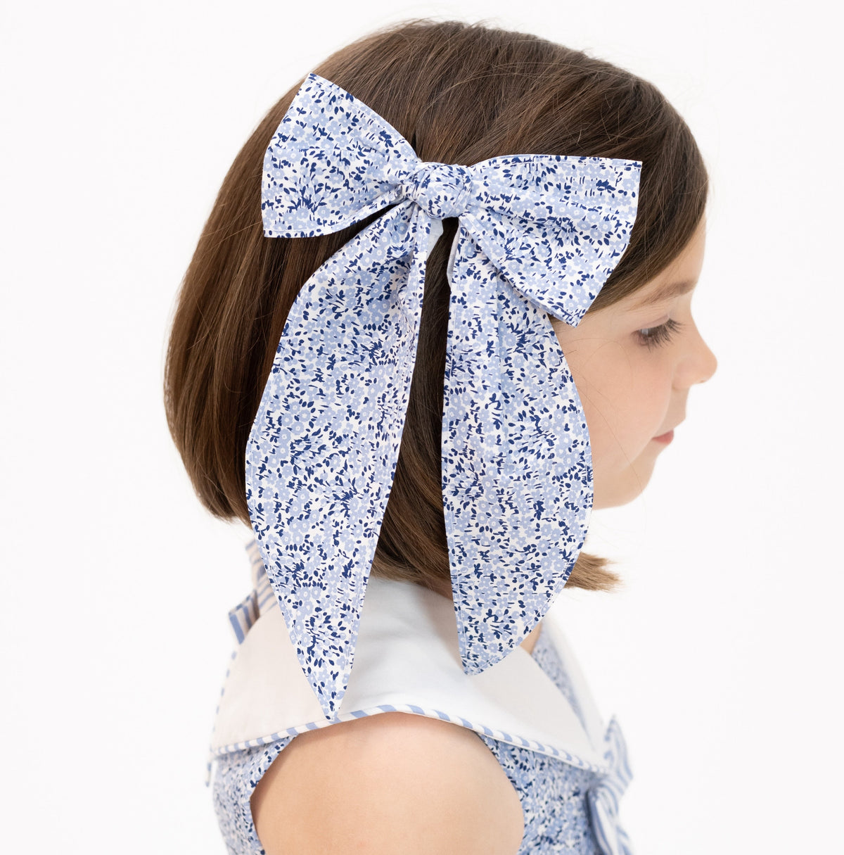 Close-up front view of Anchor Bow showcasing blue patriotic floral pattern on a child against a white background