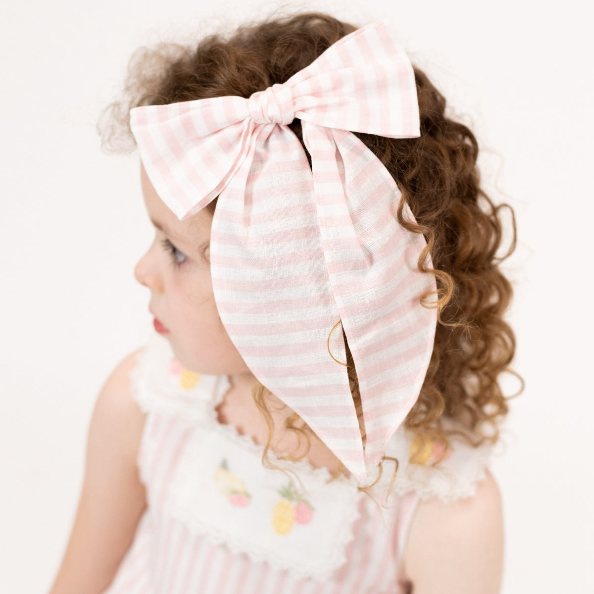 Close-up of Ananas Bow showcasing its pastel print on a child with a softly blurred light background