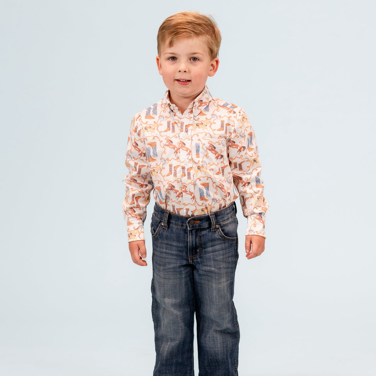 Front view of Wilson Boy button-down showing orange and blue western boot print and chest pocket on pale blue background