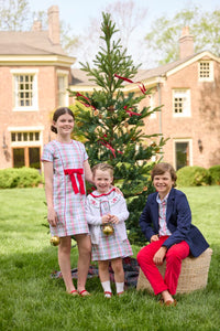 Little English classic children's clothing. Girls A-line Cora Dress in red and green plaid with red bow and red piping detail for the holidays.  Boys Douglas Plaid button down shirt with red corduroy pants and navy wool blazer. Toddler girls Eleanor Dress - Douglas Plaid with ruffled peter pan collar and tie sash in back paired with white Holiday Bow Fair Isle Cardigan