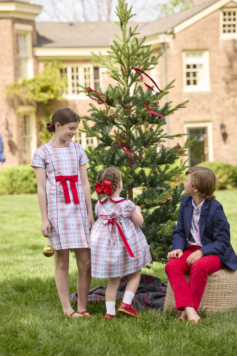 Little English classic children's clothing. Girls A-line Cora Dress in red and green plaid with red bow and red piping detail for the holidays.  Boys Douglas Plaid button down shirt with red corduroy pants and navy wool blazer. Toddler girls Eleanor Dress - Douglas Plaid with ruffled peter pan collar and tie sash in back.