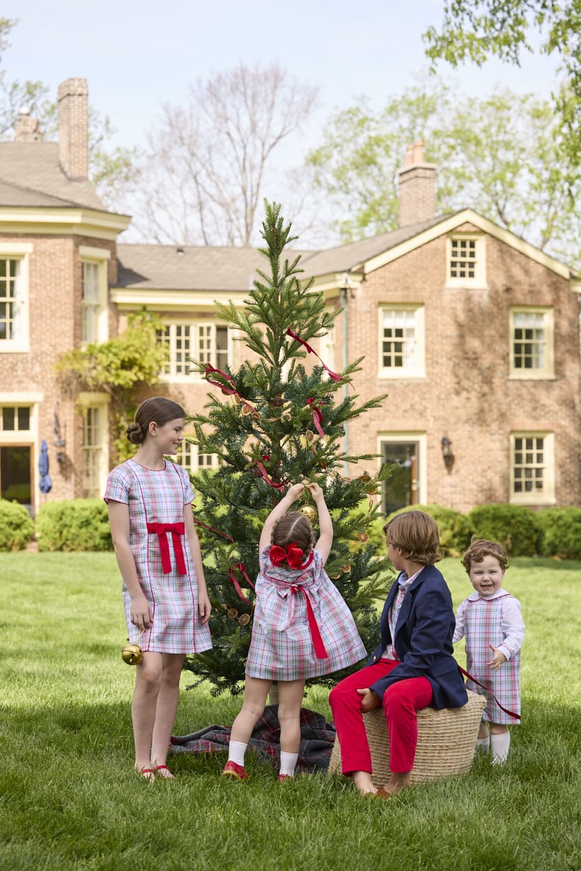 Little English classic children's clothing. Girls A-line Cora Dress in red and green plaid with red bow and red piping detail for the holidays.  Boys Douglas Plaid button down shirt with red corduroy pants and navy wool blazer. Toddler girls Eleanor Dress - Douglas Plaid with ruffled peter pan collar and tie sash in back. Toddler boys Douglas Plaid Button Tab John John Set