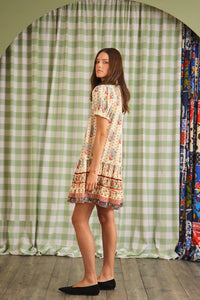 The Drifter Mini has a collared neckline, short puff sleeves, a drop waist and flounce hem.
