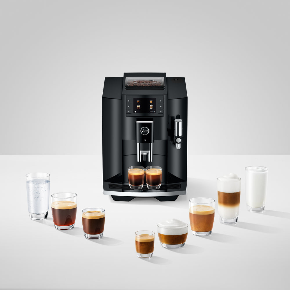 Front view of E8 Piano Black showing touchscreen, bean hopper, milk frother, and dual spouts on white background