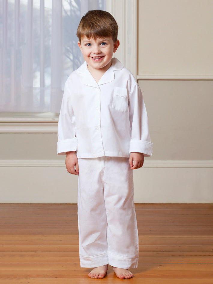 Front view of Harper 2-piece set on child model showing white button-front top and straight pants on hardwood floor