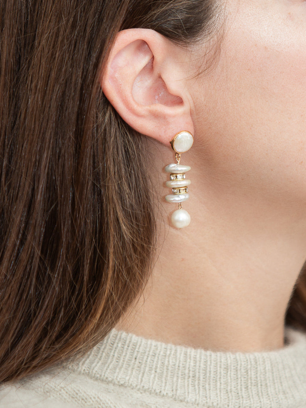 Close-up side view of Elsa Earrings in white showing stacked freshwater pearls dangling from gold-plated posts on a model’s ear