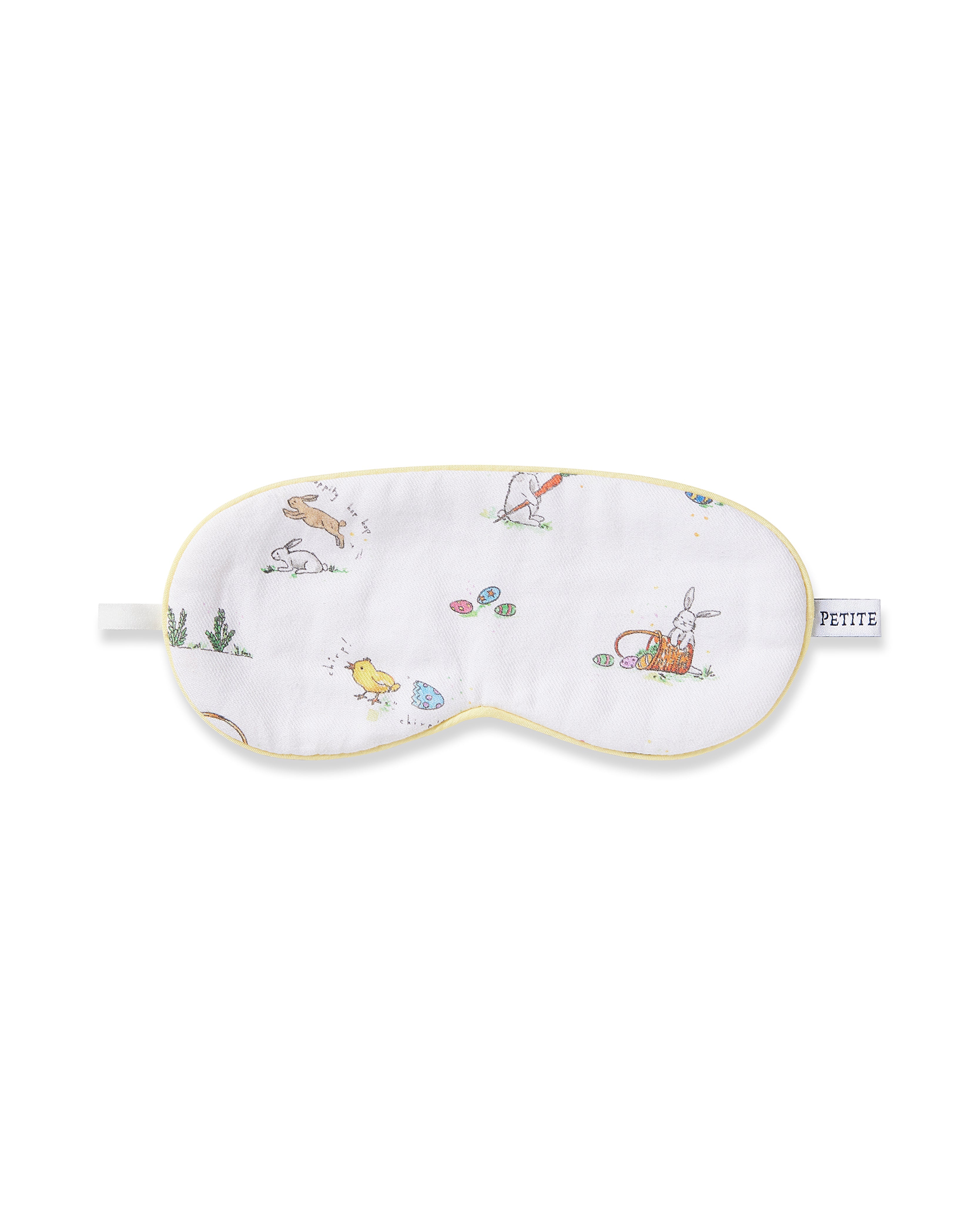 The Kids Twill Sleep Mask in Easter Frolic by Petite Plume features whimsical rabbit, chick, and Easter egg illustrations with yellow trim, complete with a subtle Petite label—perfect as a charming monogrammed gift or for matching eye masks.