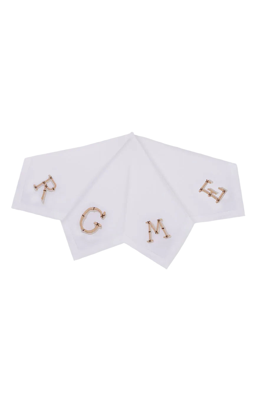 Flat lay of four white linen napkins with bamboo-inspired gold monogram embroidery and hand-finished hemstitch border on white background