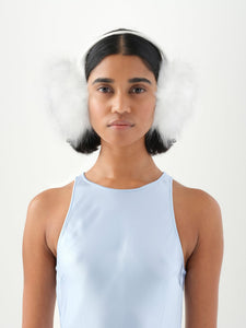 A model viewed from the front wearing white faux fur earmuffs.