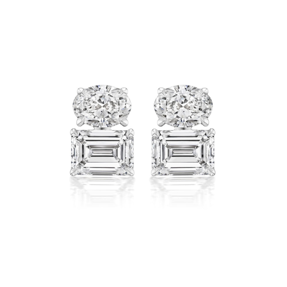 A pair of East-West Set Oval and Emerald Cut Diamond Studs in white gold is displayed against a white background.