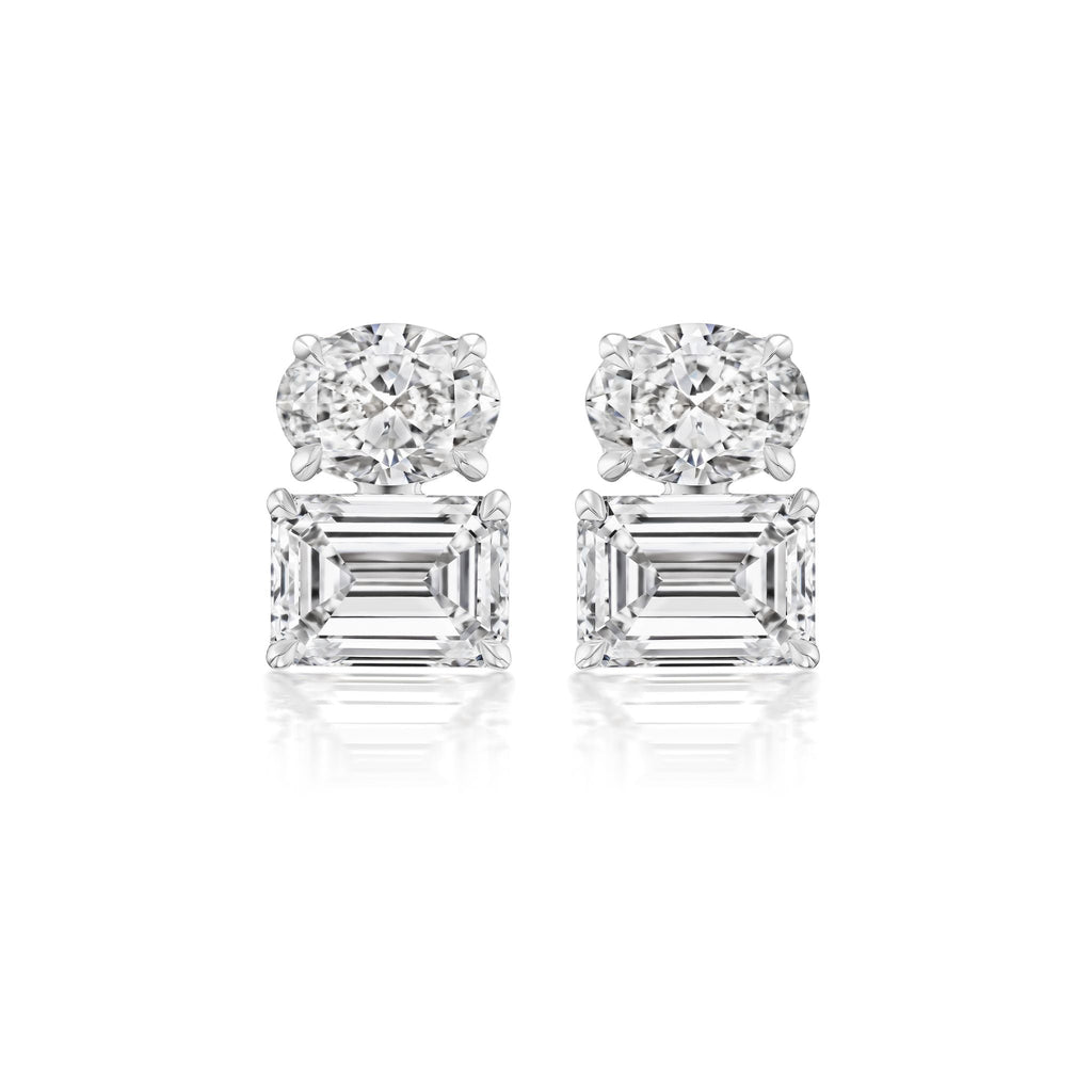 A pair of East-West Set Oval and Emerald Cut Diamond Studs in white gold is displayed against a white background.