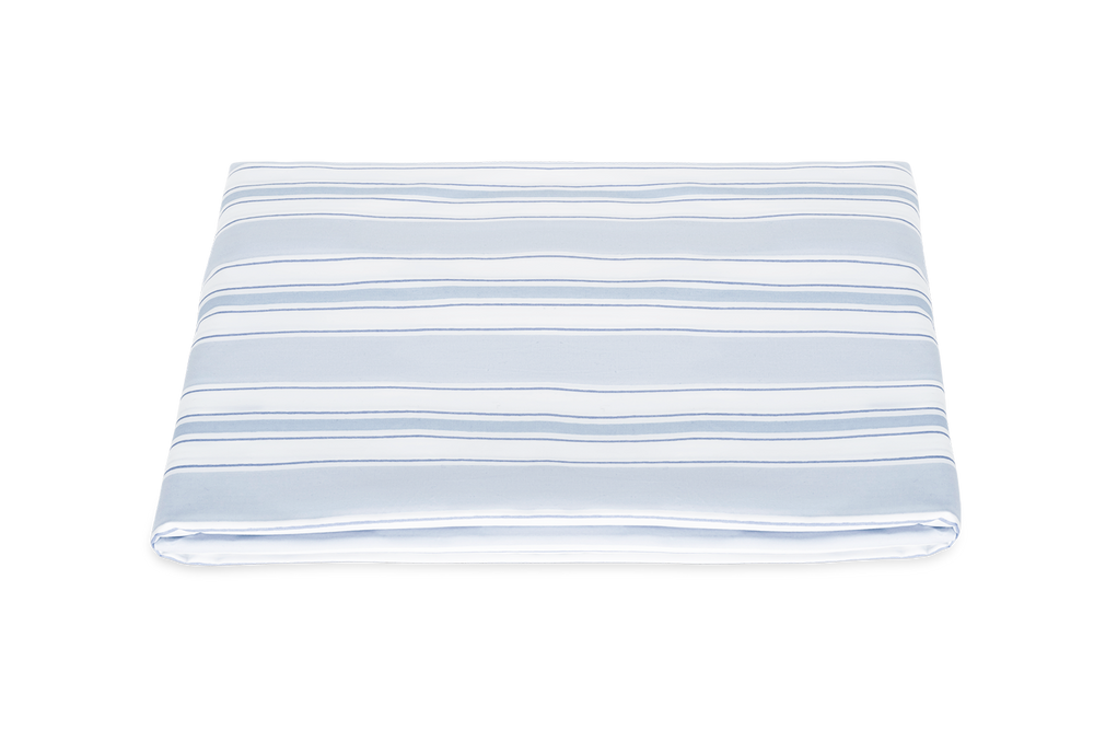 Folded Elio fitted sheet showcasing blue hand drawn stripes on a white background