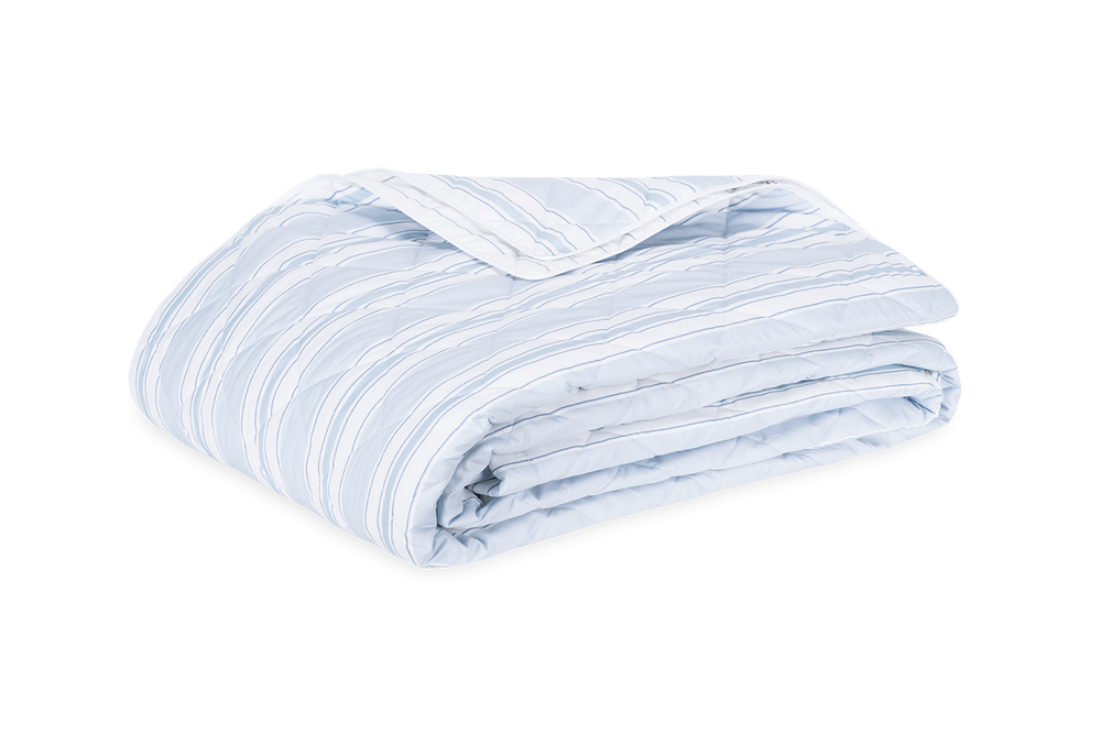 Folded Elio Quilt showcasing light blue hand-drawn stripes and quilted stitching on white background