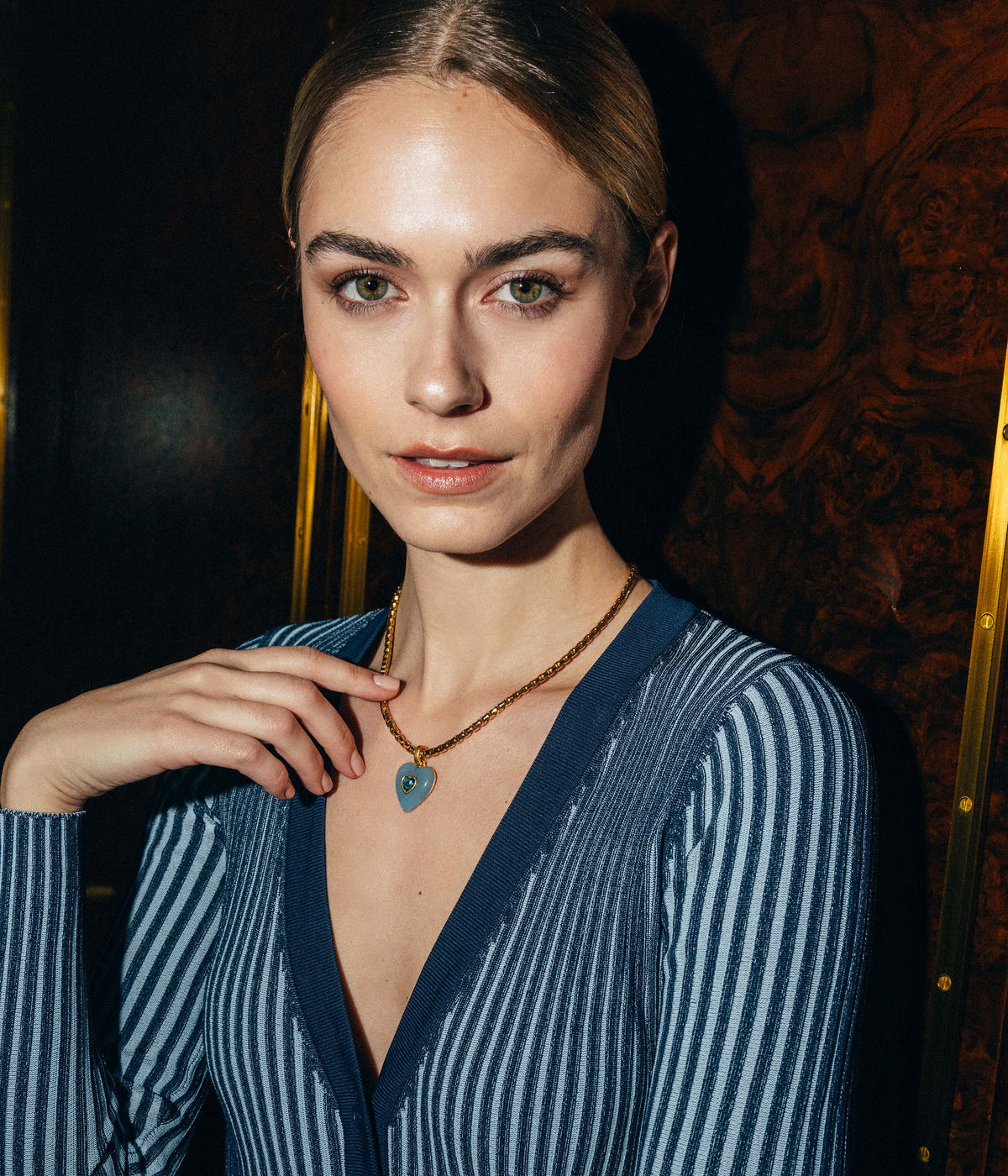 Close-up of Elodie Heart Pendant showcasing a blue resin heart with an inlaid blue crystal heart on a model