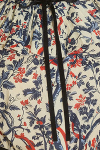 The Eloise Blouse is framed by a pleated yoke, a high ruffled collar, and tied with velvet ribbon. 