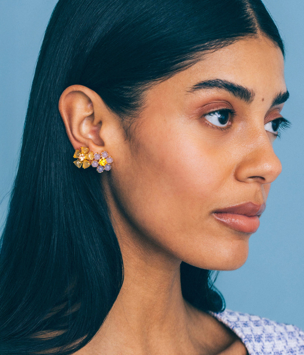 Right profile of Emeline Flower Studs in lavender showing clustered cabochons and crystals in gold on model against light blue background