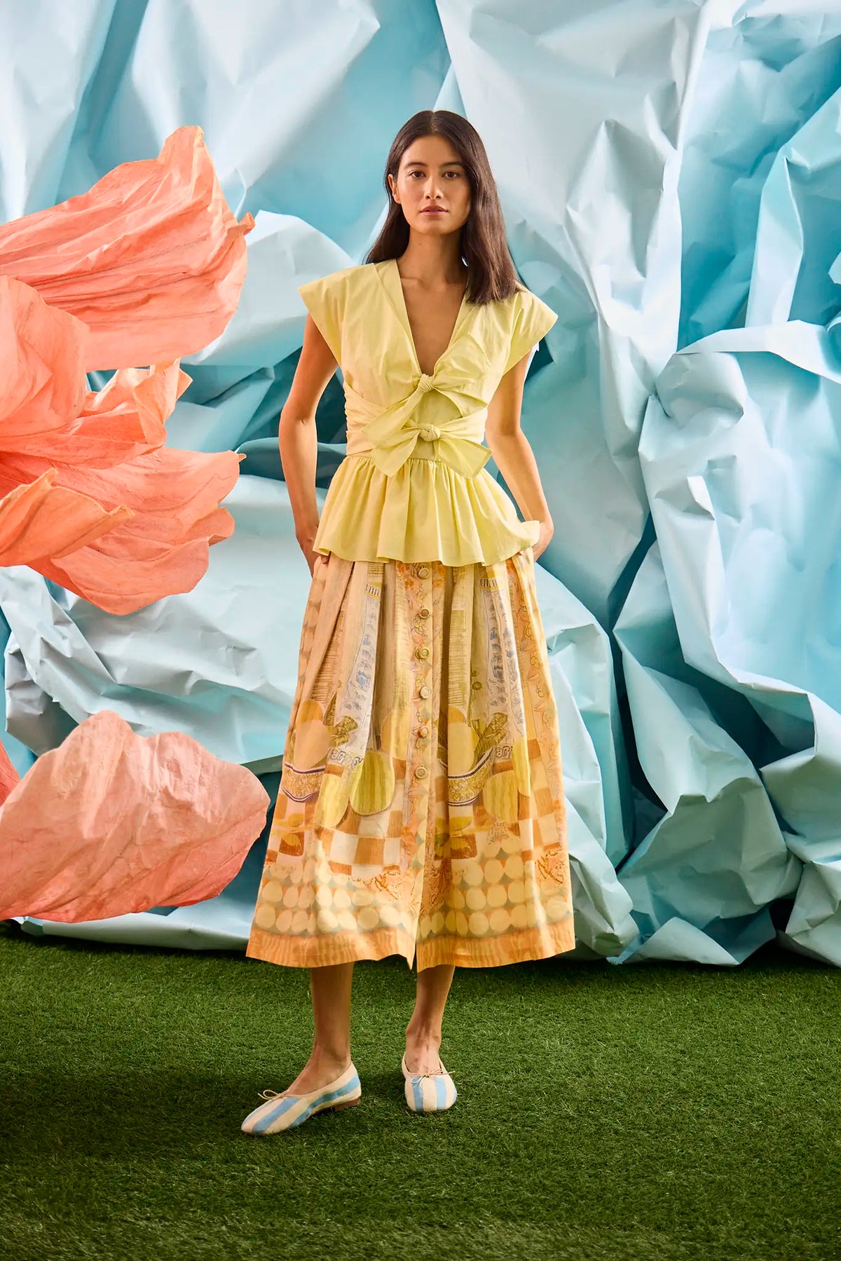 Eva Skirt in Still Life Symphony paired with Everly Top in Lemon Meringue, in front of colorful wall.