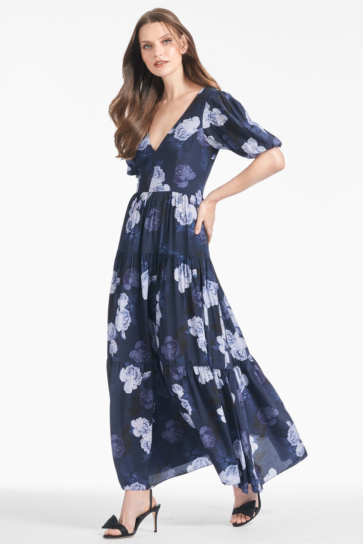 Three quarter view of Carina Dress in Midnight Glacial Rose showcasing puff short sleeves and floral print on model