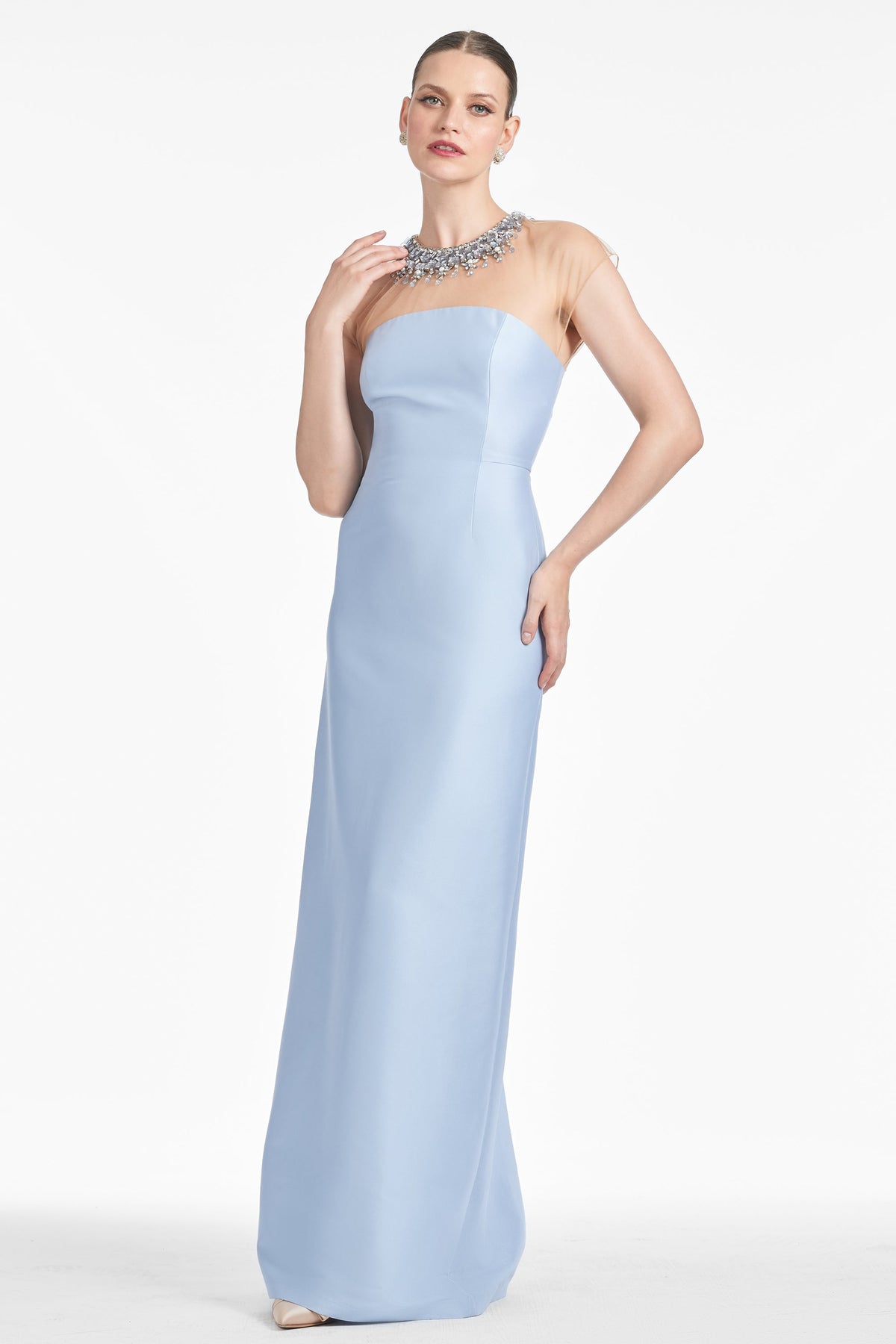 Front view of Irina Gown in Glacial Blue showcasing its beaded illusion neckline and column silhouette with a white studio background