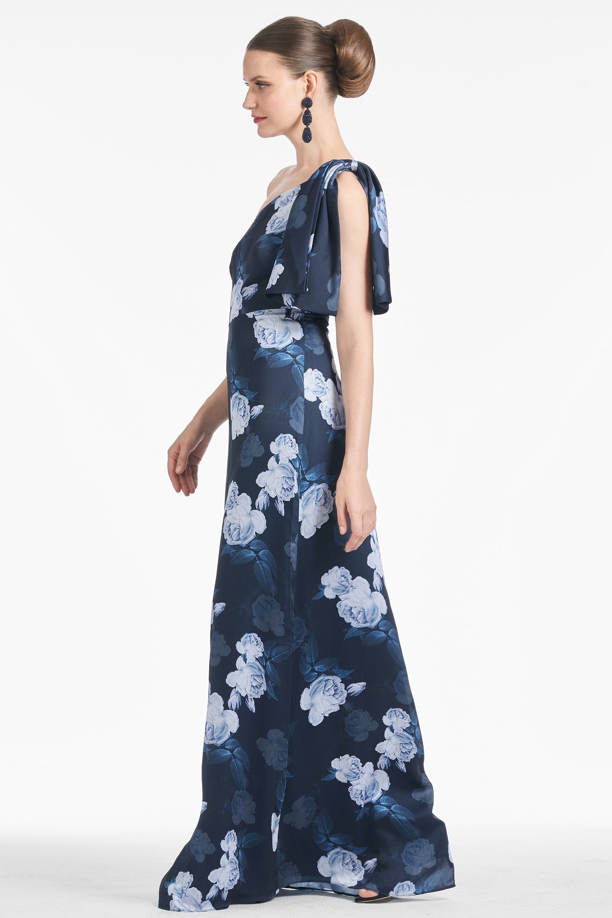Side view of Chelsea Gown in Midnight Glacial Rose showcasing its column silhouette, collapsed shoulder bow, and floral print