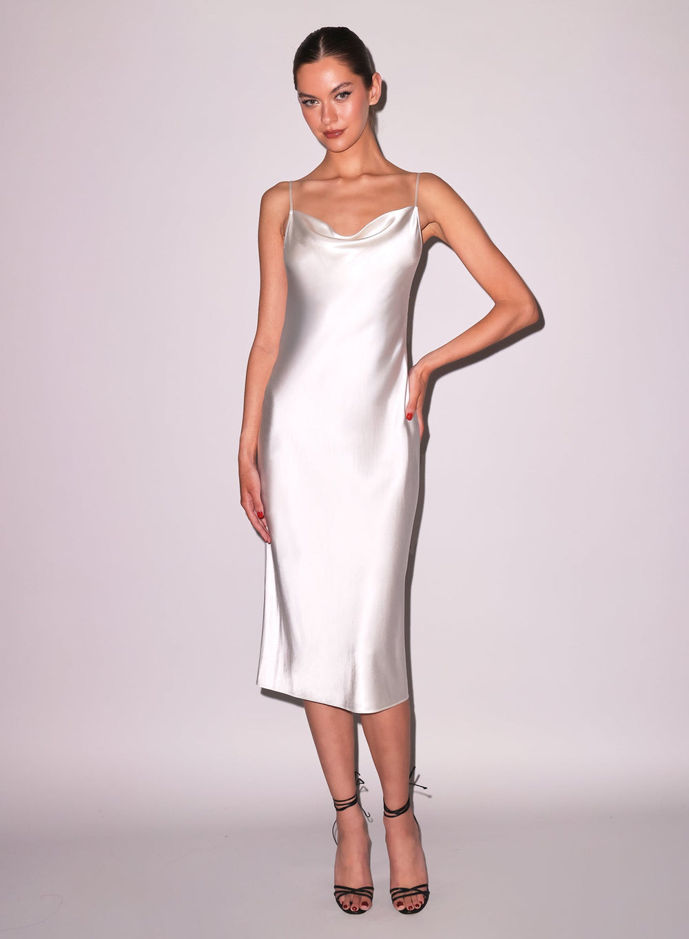 Front view of ivory cowl-neck silk midi slip dress with draped neckline, adjustable straps and bias cut on pale background