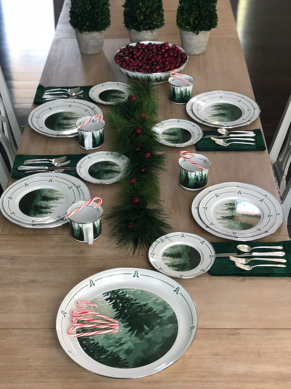 Forest Glen dinner plates arranged on a festive table with greenery, mugs, utensils, and cranberries