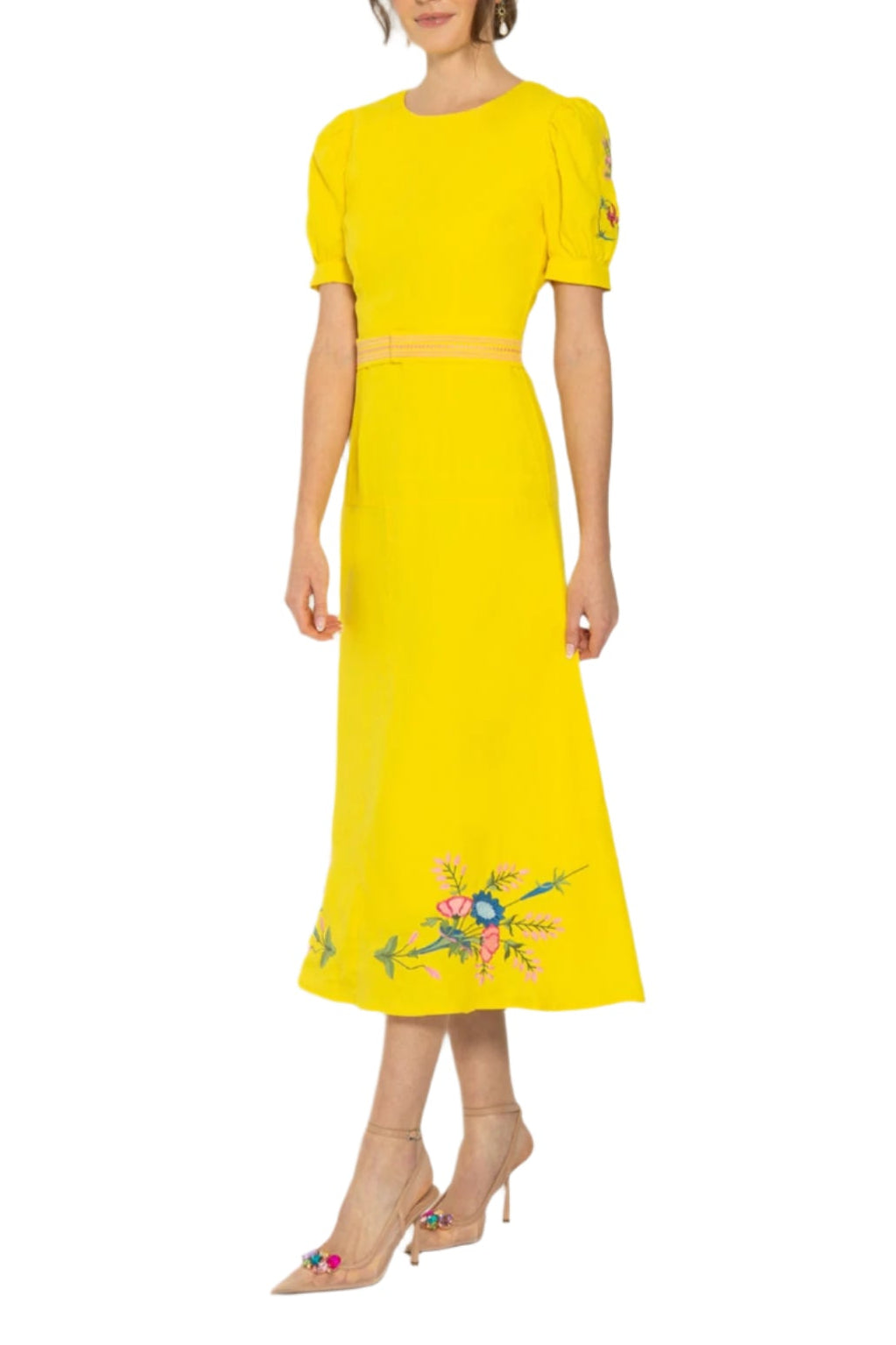 Side view of Aysin dress in bright yellow with puff sleeves, belted waist, and floral embroidery at hem on white background