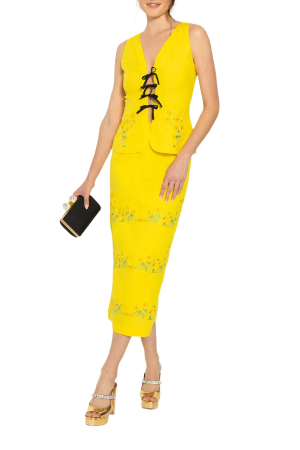 Front view of Cenan skirt set showcasing bright yellow sleeveless tie-front peplum top and embroidered high-waist midi skirt on white background